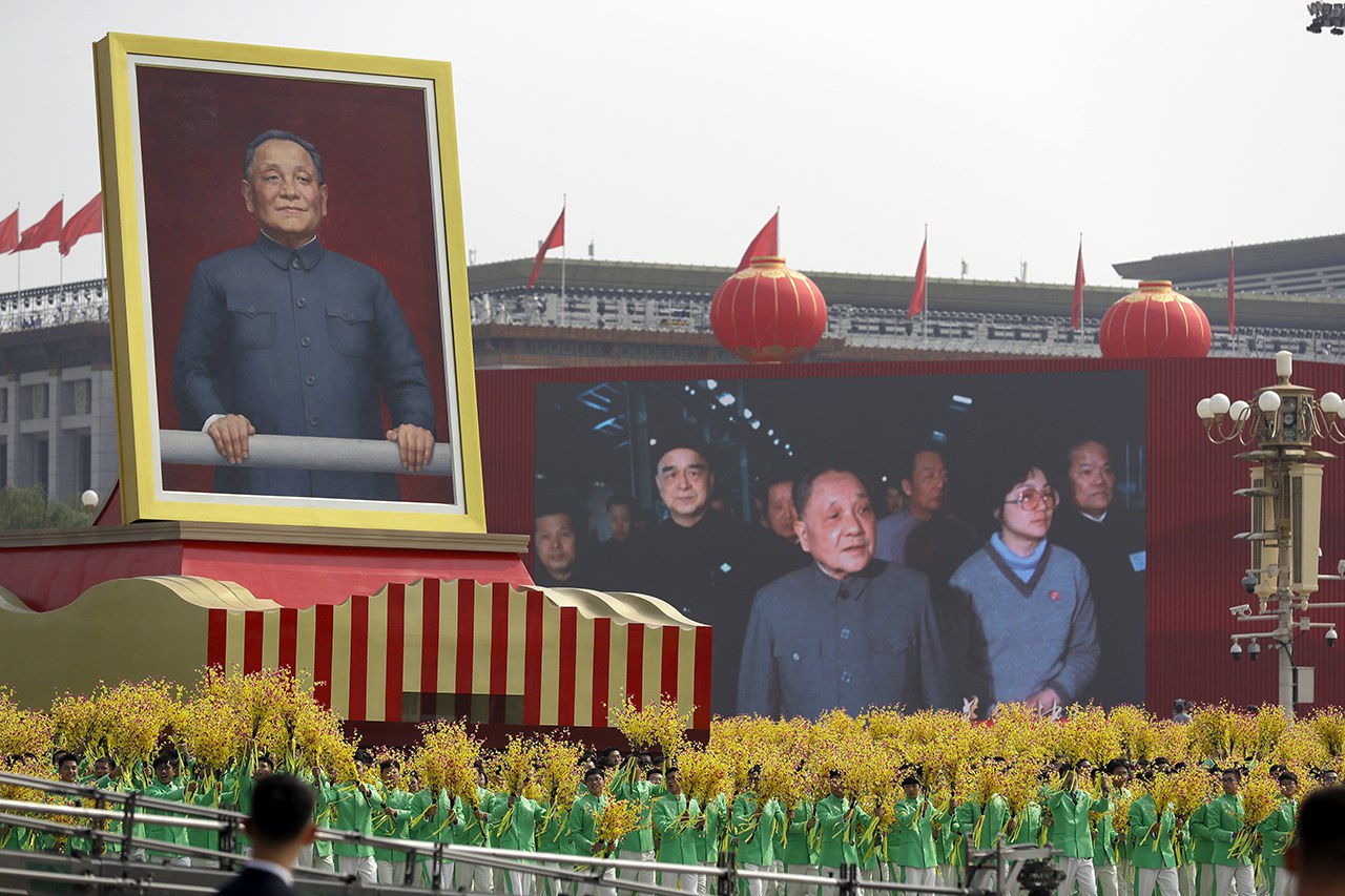 jj1.jpg 2019年10月1日,中共建政70周年庆典上,持花的游行队伍环绕巨型的邓小平画像。(美联社资料图片)