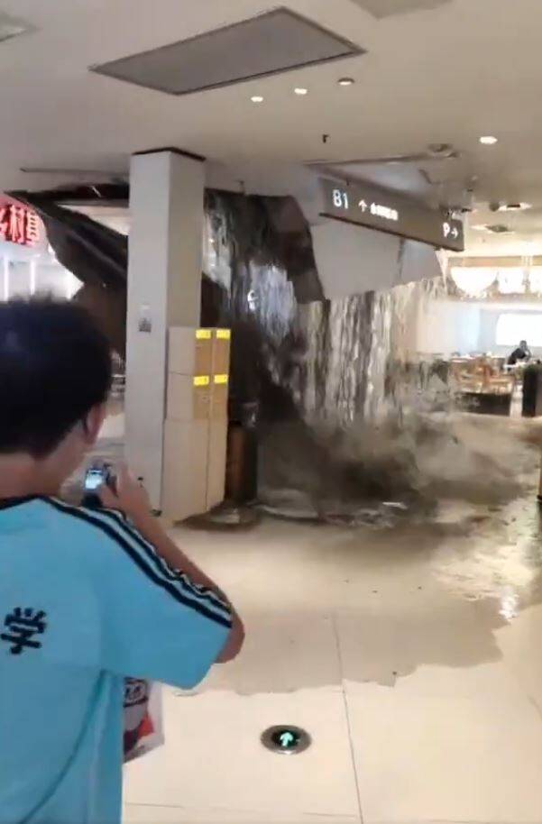 重庆一间商场因为扛不住暴雨,天花板突然垮下,大量雨水挟带泥沙倾泻而下,卖场中的顾客惊呼连连,四下奔逃。(撷取自微博) 重庆一间商场因为扛不住暴雨,天花板突然垮下,大量雨水挟带泥沙倾泻而下,卖场中的顾客惊呼连连,四下奔逃。(撷取自微博)