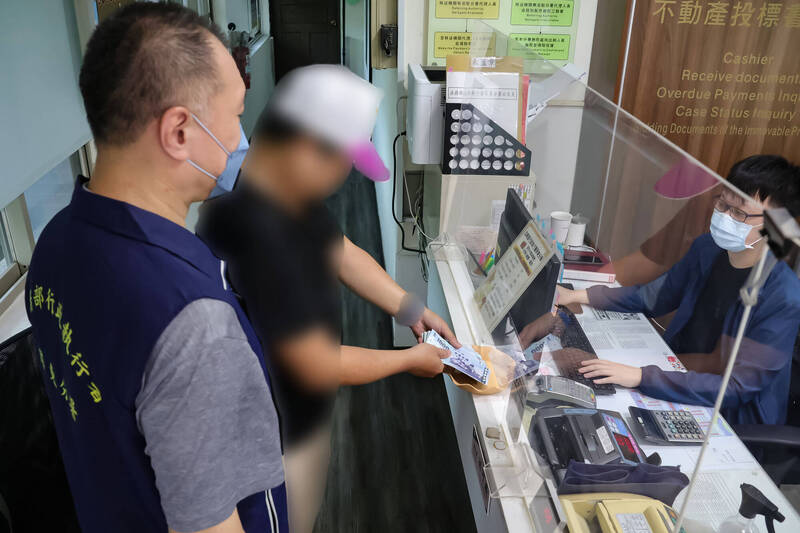 屏东执行分署与高雄区监理所屏东监理站、公路局合作，针对没有缴交罚单专案进行强力催缴。图为欠款民众到屏东执行分署缴清罚锾。（屏东执行分署提供）