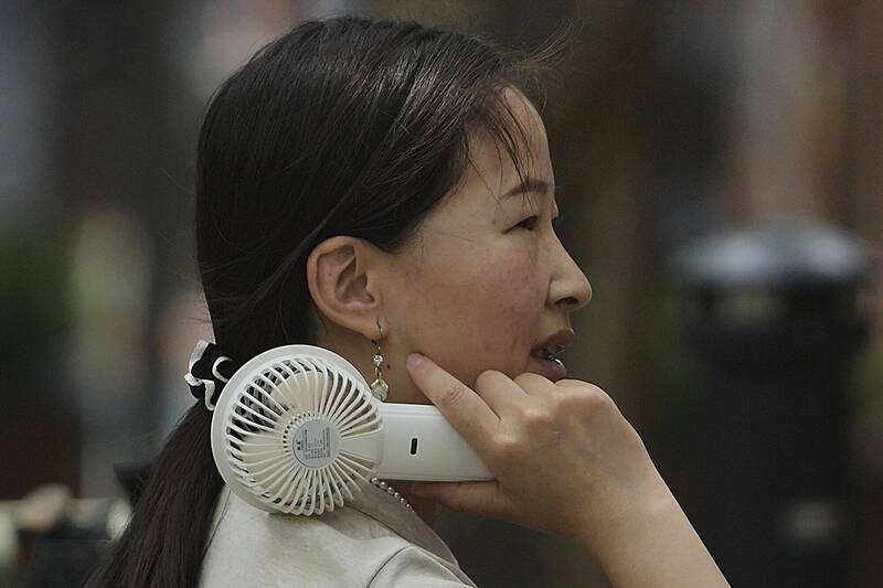 炎炎夏日，不少人外出都会自备手持电扇降温消暑。示意图，与新闻事件无关。（美联社）