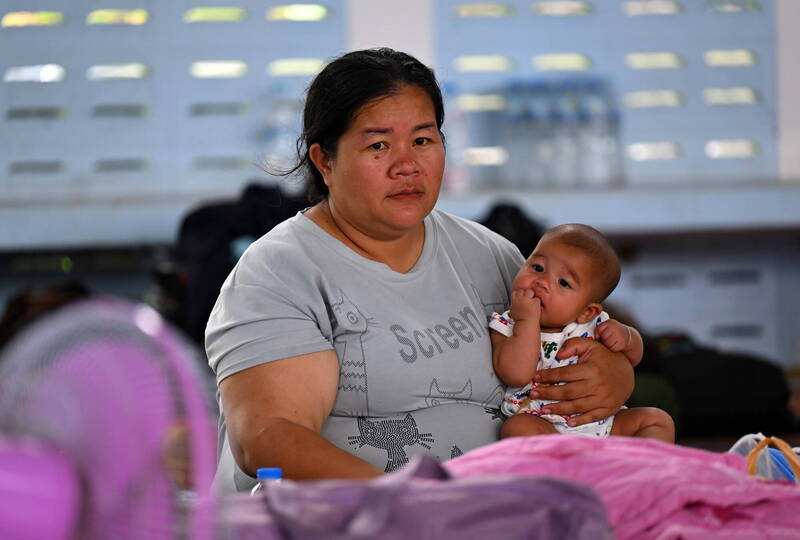 泰柬冲突已造成至少14死。图为在泰国疏散中心的妇女抱著婴儿。（欧新社）