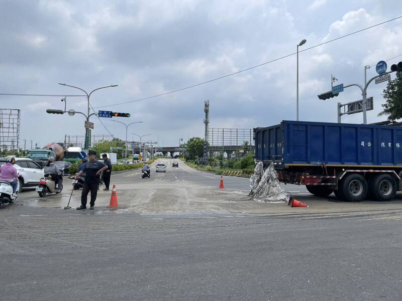 台南新市区新港社大道通往国8路口，25日一辆环保公司载送的污泥散落一地，用路人抱怨臭气薰天，厂商调派人员清理现场。（读者提供）