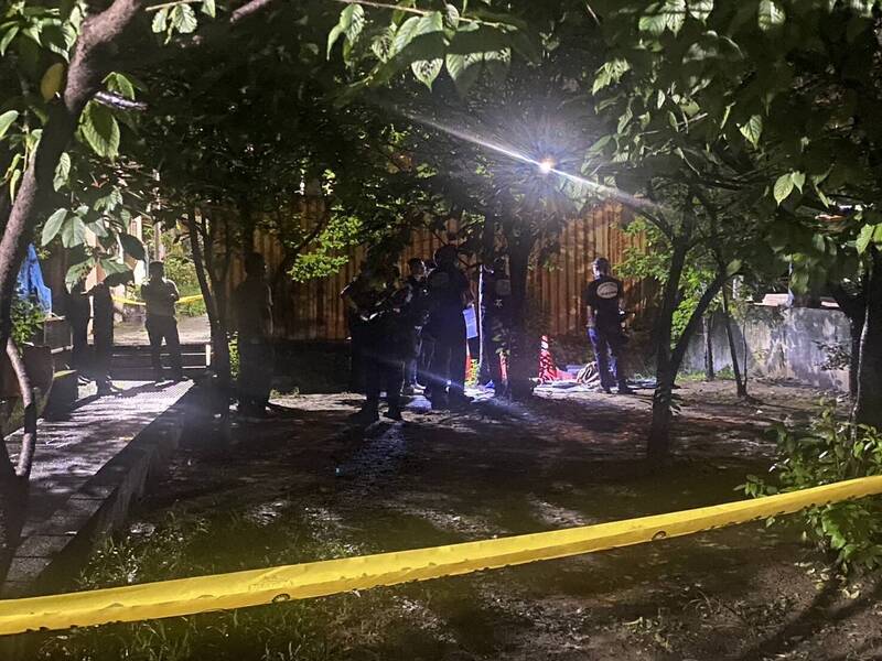 新北市新庄一处排水沟内的行李箱飘出腐臭味，惊见一具男尸被包在黑色垃圾袋中弃尸，警方封锁现场采证。（记者徐圣伦翻摄）