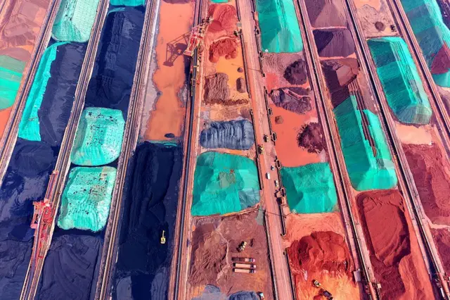 2025年3月6日，在中国东部山东省青岛港，进口铁矿石从船上卸载后被分类堆放。