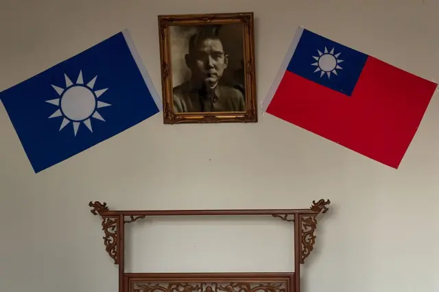 在中国陕西省西安华清宫五间厅的一间会议室内，悬挂的国民党党旗与中华民国国旗之间，展示着一幅孙中山的肖像。