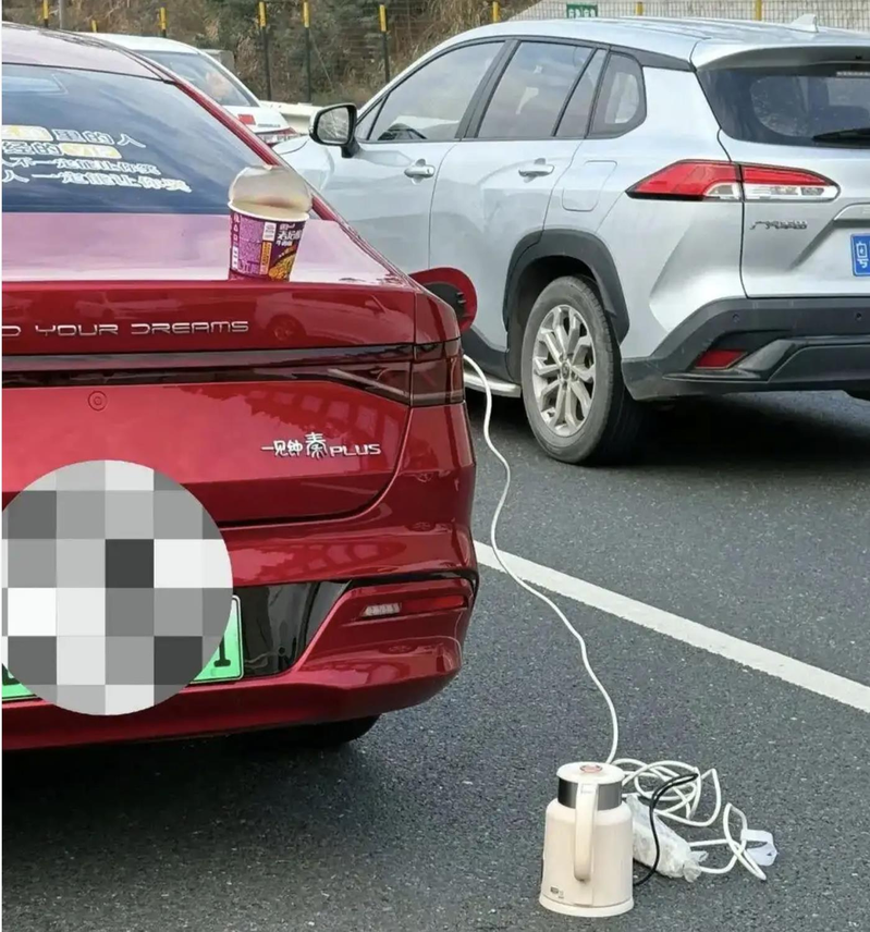 中国民众春节前自驾返乡,由于塞车太久,有人在高速公路的车阵里煮开水方便面。(环球网...