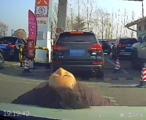 女子为了让自家车插队,直接仰躺在后方车辆的引擎盖上。(视频截屏)