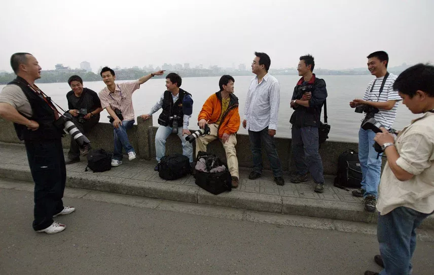 当年，“初代同事”们一起在西湖断桥等一场雨。受访者供图