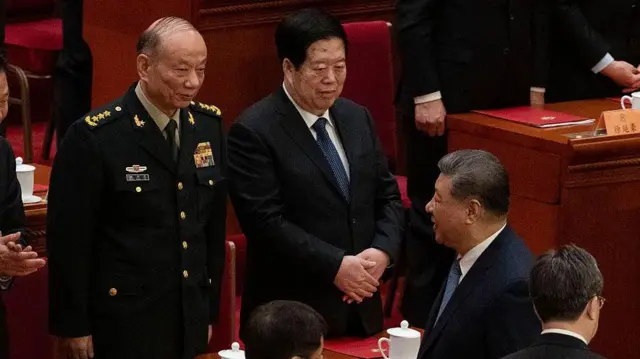 3月11日在中国北京人民大会堂举行的中国人民政治协商会议(全国政协)闭幕会结束时,习近平与中央军事委员会副主席张升民(左)对望。