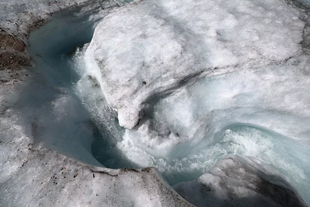 当地时间2025年8月11日，德国加米施-帕滕基兴，楚格峰的施尼费尔纳冰川，冰雪融化形成水流。专家表示，预计将在一两年内失去冰川的部分特征，并将在2030年左右完全消失。视觉中国 图