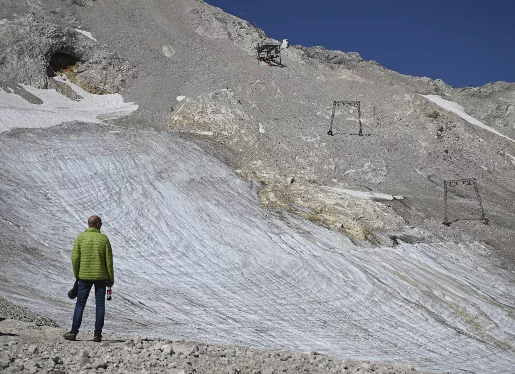 当地时间2025年8月8日，德国，一名男子在北施内费纳冰川看到被拆除的滑雪缆车。视觉中国 图