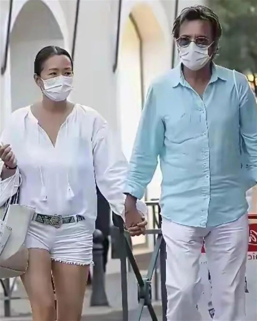 巩俐夫妻俩现身法国街头，吊带裙尽显丰满野性