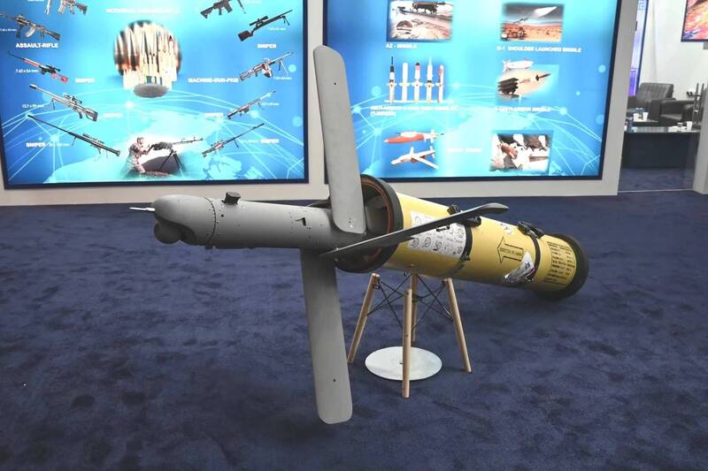 伊朗德黑兰命名为「雷兹万」（Rezvan，意为天堂守门者）的新型自杀无人机（代号GLMD-24W4.5-R2），在国防展览会上的展示画面。图片可见其管射式的机身设计，前端设有可即时传输影像的光电寻标器，并配有折叠式的控制翼面与推力螺旋桨。 （取自Army Recognition Group）